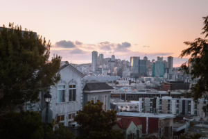 Capture the charming urban skyline of San Francisco as the sun sets, casting a warm glow over the city.